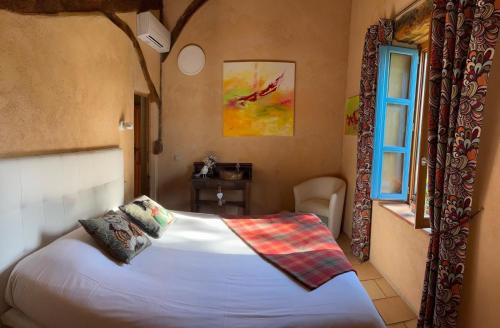 1 dormitorio con cama y ventana en Le Clos Pastel, en Virac