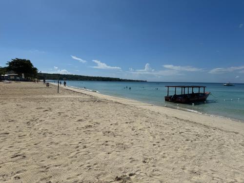 a boat in the water on a beach at Marriott White Sands, BeachFront Condo at Negril Beach Club in Negril