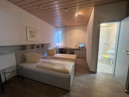 two beds in a room with a bathroom at Hotel Cronberger Hof in Ladenburg