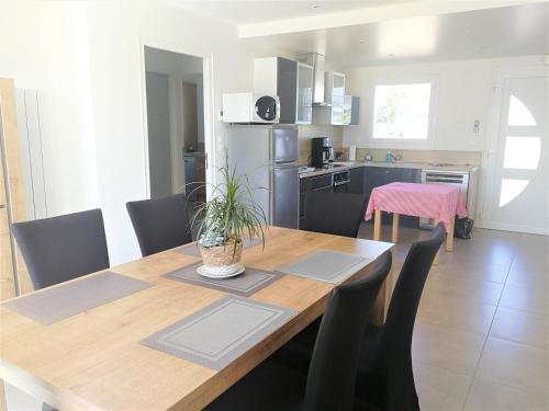 une cuisine et une salle à manger avec une table et des chaises en bois dans l'établissement PLAGES A PIED, à Saint-Coulomb