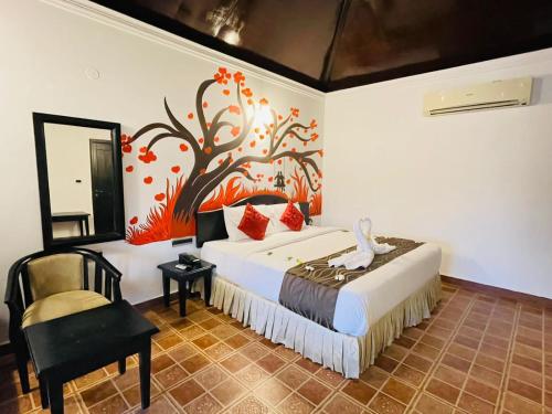 a bedroom with a bed with a tree mural on the wall at The Four Season Beach Resort - Best Selling Property in Gokarna in Gokarna