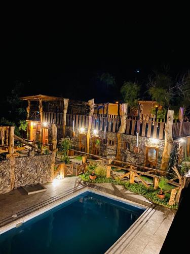 une piscine en face d'une clôture la nuit dans l'établissement Cabañas Rusticas Olimpus del Elqui, à Vicuña