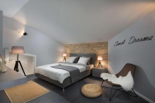 a bedroom with a bed and a chair at Villa Fabiana, a luxurious and spacious villa, few minutes from the beach in Labin