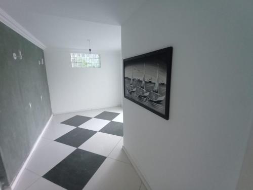 a white room with a black and white checkered floor at Cantinho do Sossego in Rio de Janeiro