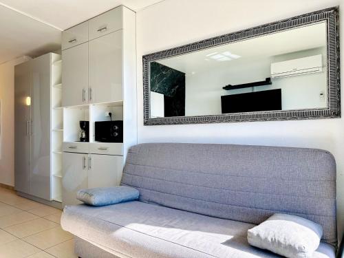 een woonkamer met een bank en een spiegel bij Seaview Apartment in Empuriabrava