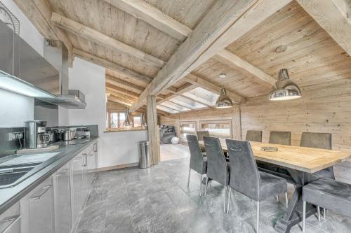 - une cuisine avec un plafond en bois, une table et des chaises dans l'établissement Appartement Equinox, à Megève
