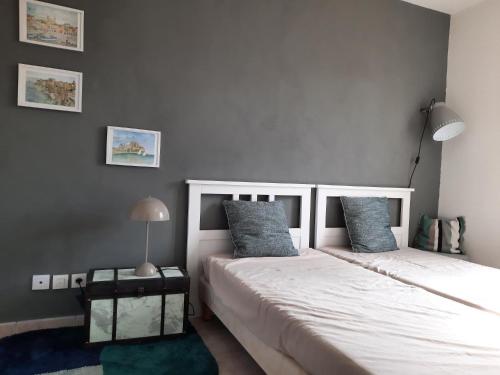 une chambre avec deux lits et une lampe dans l'établissement La Maison de Nat, à Nyons