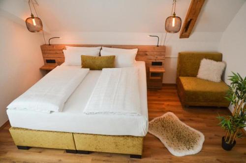 ein Schlafzimmer mit einem großen Bett und einem Stuhl in der Unterkunft Gasthof zum Ritter in Ulm