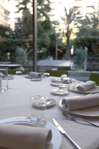 a table with white plates and silverware on it at Primus Valencia in Valencia