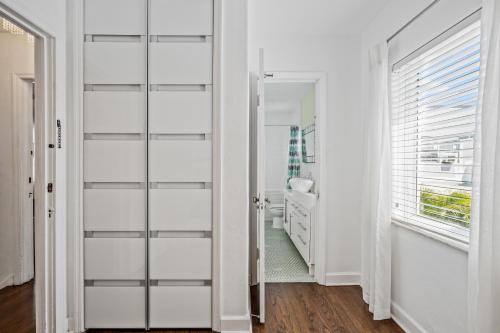 a bathroom with white walls and a glass door at Villa Venezia BB full house up to 12 guests in Miami Beach