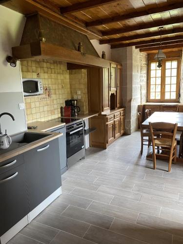 une cuisine avec un évier et une table à l'intérieur dans l'établissement La Tour de Côtebrune, à Côtebrune