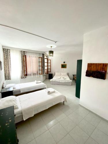 two beds in a large room with white walls at Akdeniz Pansiyon in Ekincik