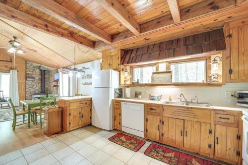 a large kitchen with wooden cabinets and a table at Creekside Cabin with Deck and Grill in Whittier! in Whittier