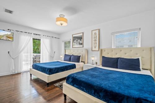 two beds in a bedroom with blue sheets at Villa Venezia BB full house up to 12 guests in Miami Beach