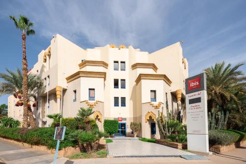 a large white building with a sign in front of it at Ibis Oujda in Oujda