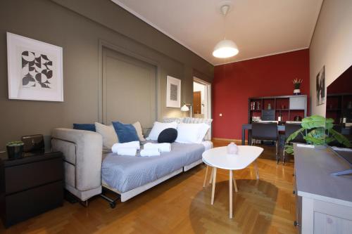 ein Wohnzimmer mit einem Sofa und einem Tisch in der Unterkunft Modern 2BD apartment next to Acropolis in Athen