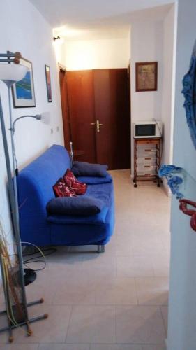 een woonkamer met een blauwe bank en een tafel bij Valledoria in Valledoria