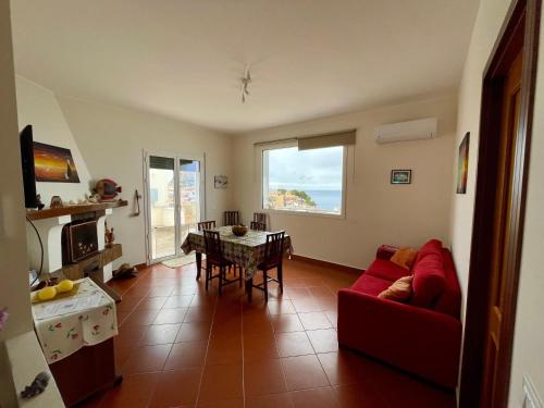 a living room with a red couch and a table at Bellavista in Santa Flavia