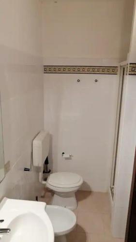 een witte badkamer met een toilet en een wastafel bij Valledoria in Valledoria