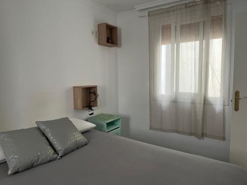 una camera bianca con un letto e una finestra di The Light appartment Tarragona a Tarragona