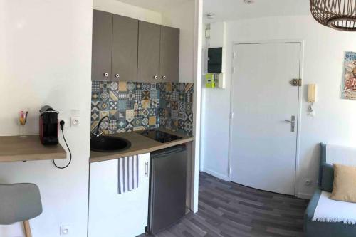 une cuisine avec un évier et un plan de travail dans l'établissement Charmant T2 avec garage à 2 pas gare/centre-ville, à Nantes