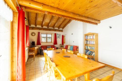 a dining room with a wooden table and chairs at Chalet Les moulins in Bonneval-sur-Arc