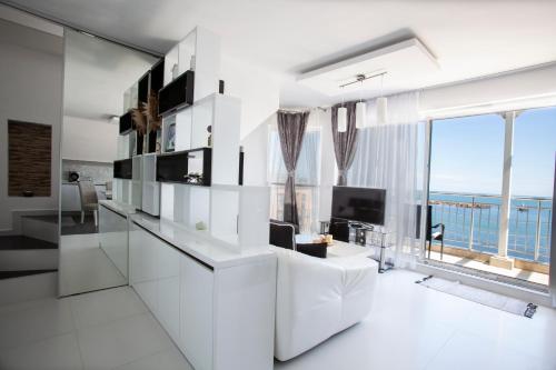 una sala de estar blanca con vistas al océano en NEA Penthouse, en Ahtopol