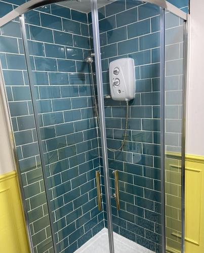 a shower stall with blue tiles in a bathroom at Stunning 2-bedroomed Cottage in Cockermouth