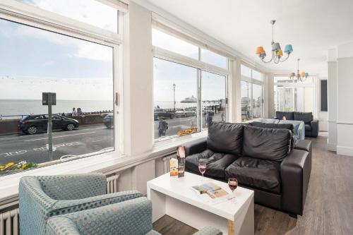 a living room with a couch and a table and windows at The Majestic Hotel in Eastbourne