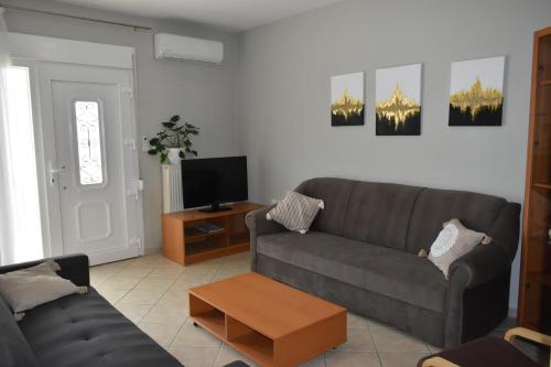 sala de estar con sofá y TV en Natalia guest house en Kavala