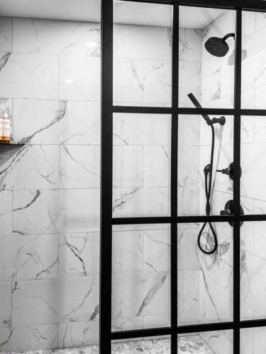a white marble wall with a shower in a bathroom at 2 King Beds, Historic DTWN Hotel, Steps 2 Restaurants Room # 405 in Bangor