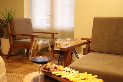 a tray of cheese and a glass of red wine at Velar Hotel Boutique in Korçë