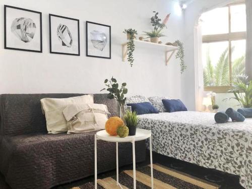 ein Wohnzimmer mit einem Sofa und einem Tisch in der Unterkunft LM27 Beach by Wave Properties in Las Palmas de Gran Canaria