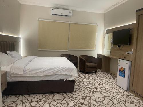 a hotel room with a bed and a flat screen tv at Dvina Hotel in Tabuk