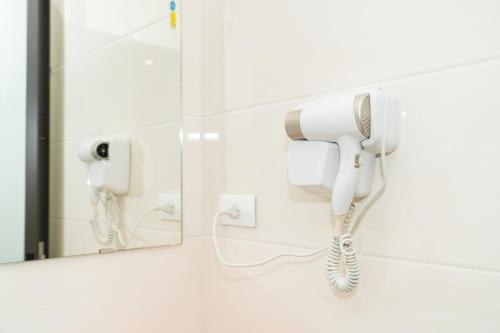 teléfono en el baño con espejo en Korea Hotel Bac Giang, en Làng Thành