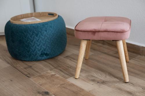 a stool and a ottoman sitting on a wooden floor at Palazzo Campia in Cortandone