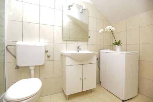 ein weißes Bad mit einem WC und einem Waschbecken in der Unterkunft Apartments Petar in Rtina