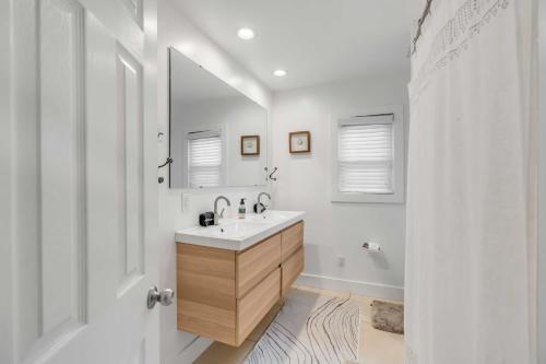 uma casa de banho branca com um lavatório e um espelho em The Oyster House Downtown em Charleston