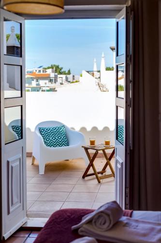 an open door to a patio with a chair and a table at Villa Oliveiras de Vilamoura by The Portuguese Butler in Quarteira