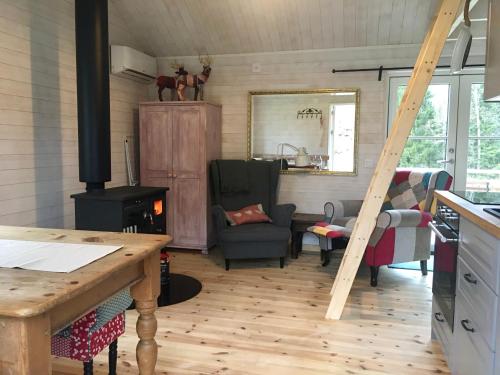 cocina y sala de estar con estufa de leña en Pippis Cottage en Tingsryd