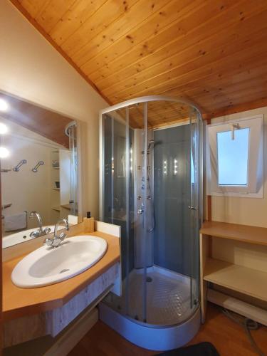 une salle de bain avec douche et lavabo dans l'établissement Chalet dans résidence les Pescalunes, à Agde