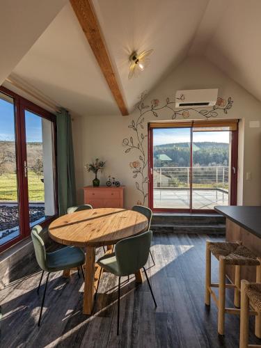 une salle à manger avec une table et des chaises en bois dans l'établissement La Rose des Vents - Appartement avec Terrasse, Piscine et Parking, à Lautenbach
