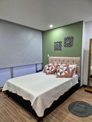 ein Schlafzimmer mit einem großen Bett mit Kissen darauf in der Unterkunft Confortable Apartaestudio - Club House Armenia in Armenia