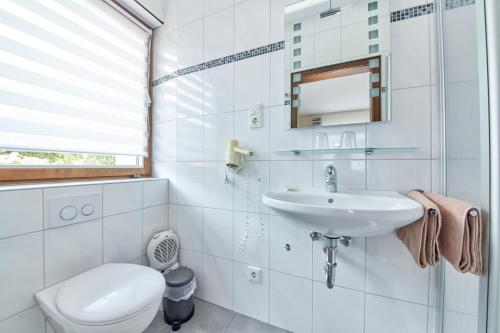 a white bathroom with a toilet and a sink at Cafe Rosi in Bernkastel-Kues