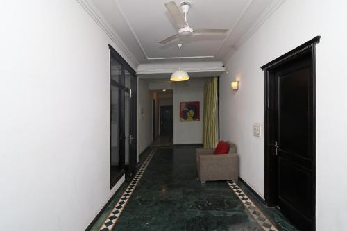 um corredor com uma cadeira e um tecto em OYO Samudra Executive em Pune