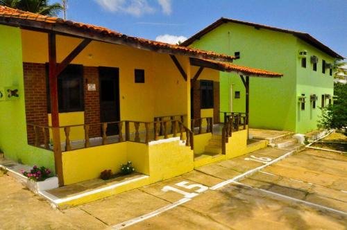 una casa verde y amarilla con aparcamiento en Pargos Club de Salinas, en Salinópolis