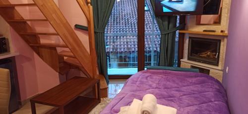 a room with a bed and a tv and a staircase at tokastro in Arachova