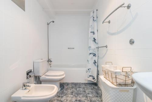 uma casa de banho branca com um WC e um lavatório em Apto. Canteras City em Las Palmas de Gran Canaria