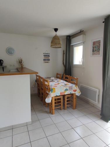 a kitchen with a table and chairs in a room at Maison 3 chambres avec piscine proche plage in Soulac-sur-Mer