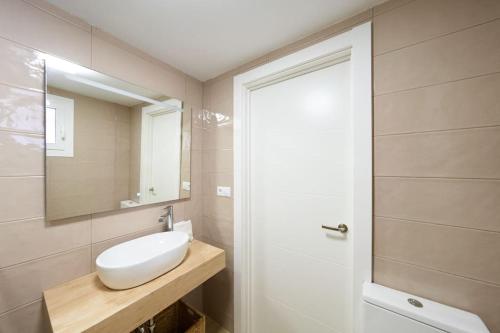 een badkamer met een witte wastafel en een spiegel bij Alborán Bajo in San José